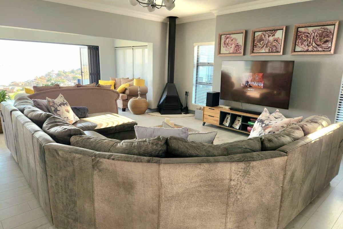 Spacious living room featuring a modern freestanding fireplace, neutral tiled flooring, and large sliding doors that open to an outdoor view.