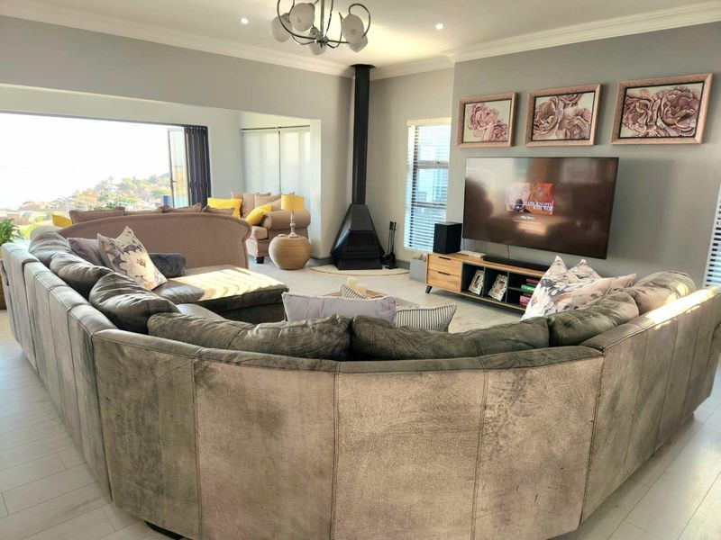 Spacious living room featuring a modern freestanding fireplace, neutral tiled flooring, and large sliding doors that open to an outdoor view.