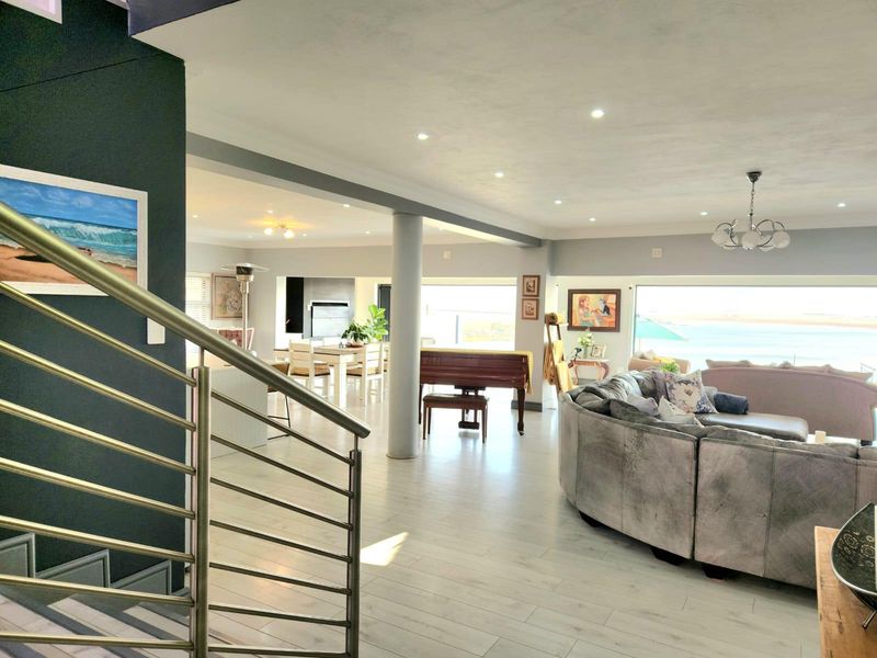 Spacious open-plan living and dining area featuring modern tiled floors, recessed lighting, and large sliding doors offering expansive views.