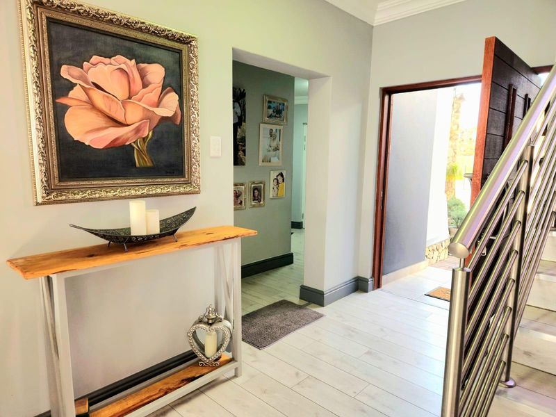 Welcoming entrance hall featuring modern tiled flooring, a contemporary stainless steel balustrade, and a solid timber front door leading to the exterior.