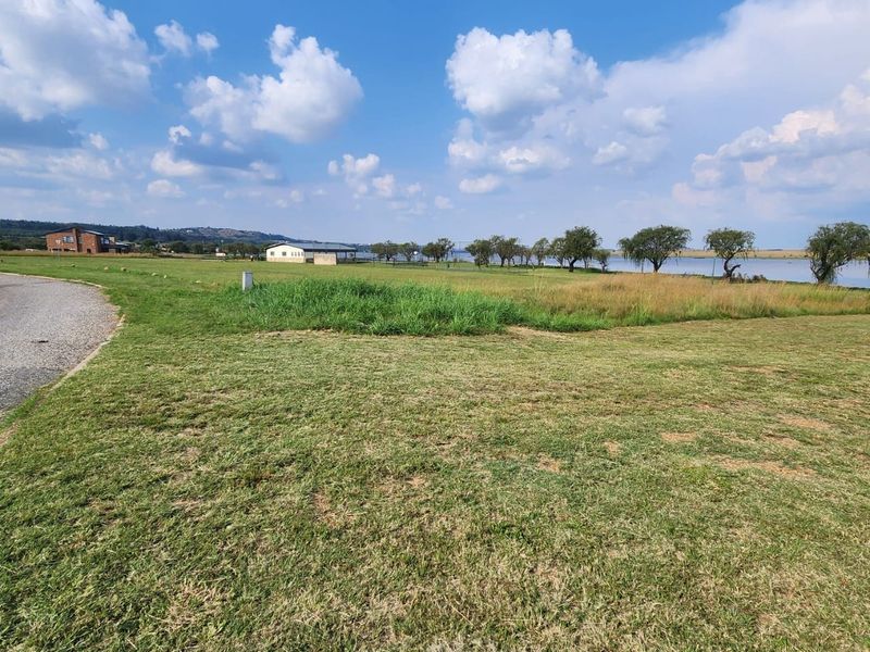 A scenic view of the vacant residential land featuring expansive green lawns and proximity to the waterfront.