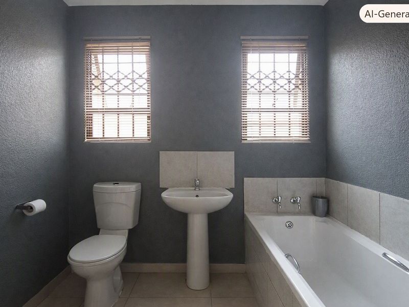A functional bathroom featuring a pedestal basin, toilet, and bathtub with neutral tiled splashbacks and dark grey walls.