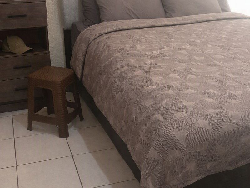 A bedroom featuring tiled flooring and a neutral color palette.