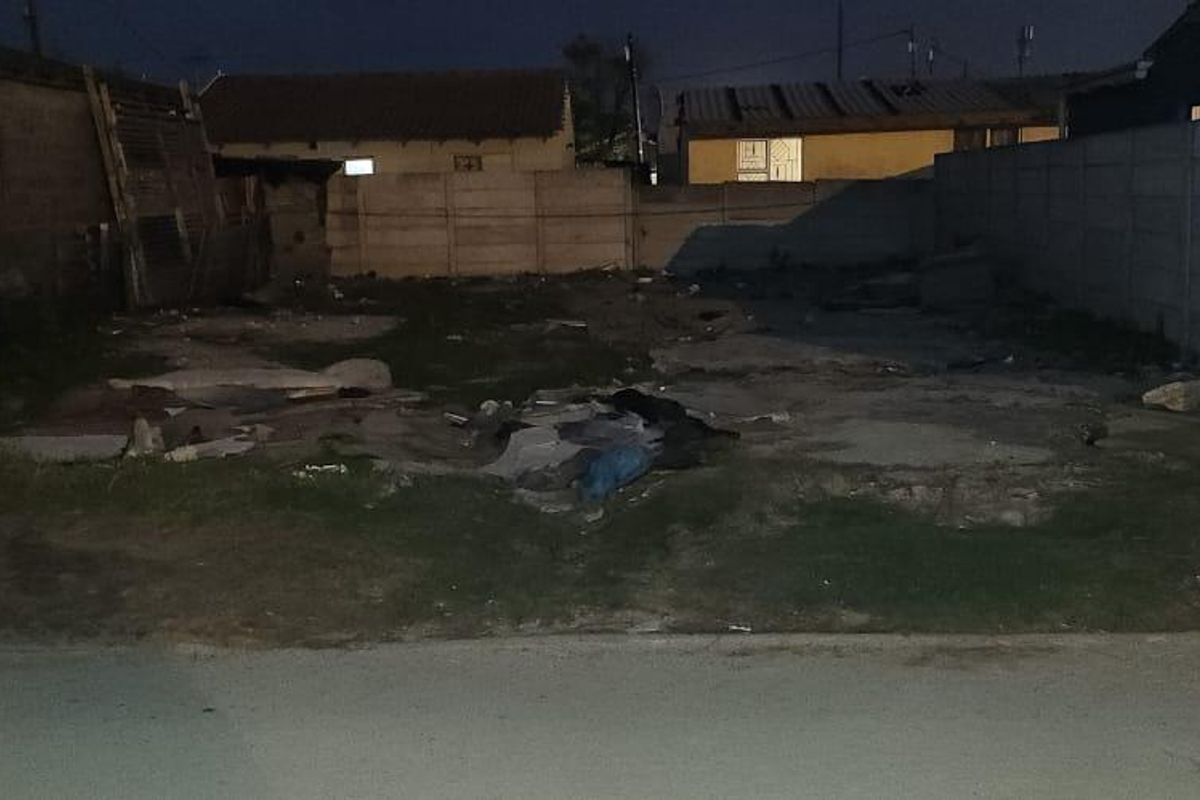 Vacant residential plot featuring a concrete slab foundation and enclosed by precast concrete boundary walls, requiring site clearing and development.