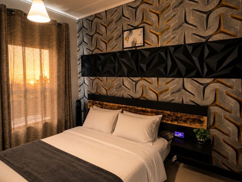 A well-appointed bedroom featuring a striking geometric feature wall, integrated headboard, and warm pendant lighting, creating a cozy and modern atmosphere.
