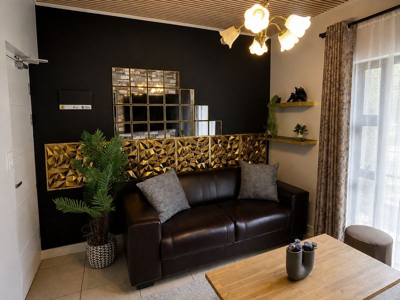 A modern living room featuring a unique slatted timber ceiling, tiled flooring, and a striking black accent wall with decorative gold panels and mirrors.