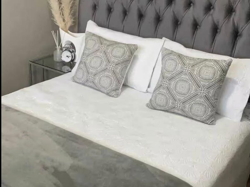 A well-maintained bedroom featuring neutral wall finishes and wood-look flooring.