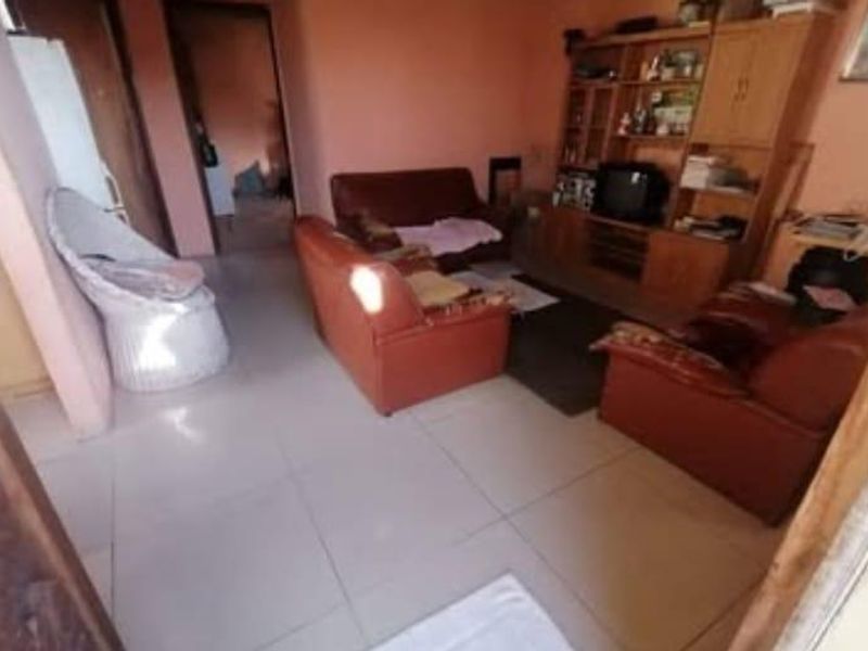 A living room area featuring tiled flooring and painted walls, providing a functional space for relaxation.
