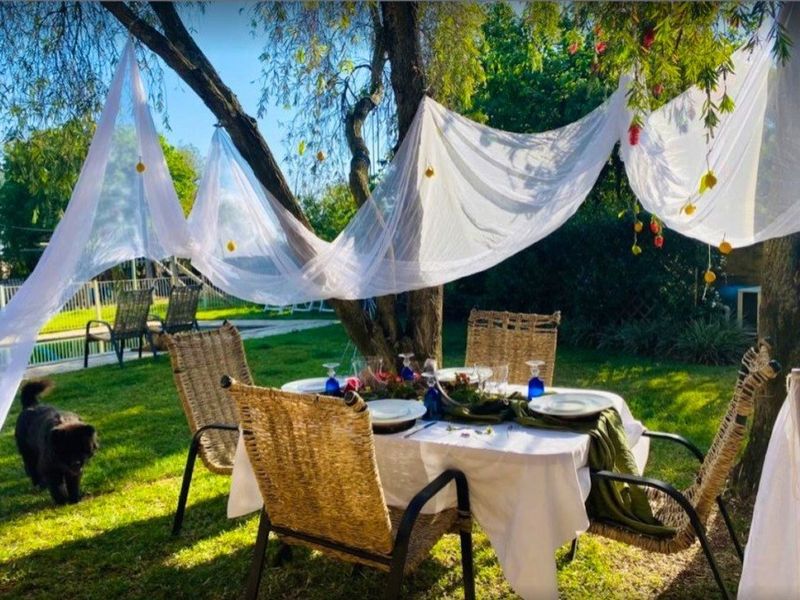 A lush, green garden setting featuring mature trees and a well-maintained lawn, suitable for outdoor dining and relaxation.