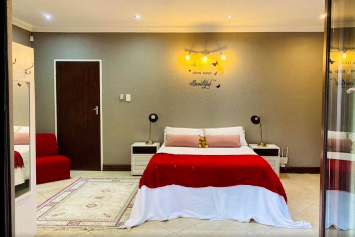 A well-maintained bedroom featuring tiled flooring, recessed downlighting, and neutral wall finishes, providing a comfortable and functional living space.