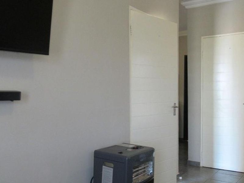 A simple living area featuring tiled flooring and white internal doors, providing a neutral base for interior design.