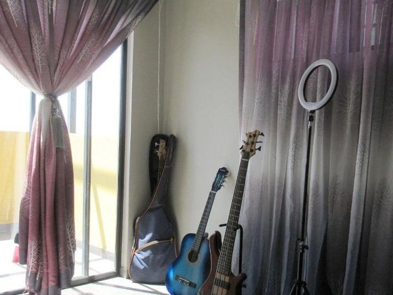 Bedroom featuring a sliding glass door providing access to an outdoor area, finished with neutral walls and curtain fixtures.