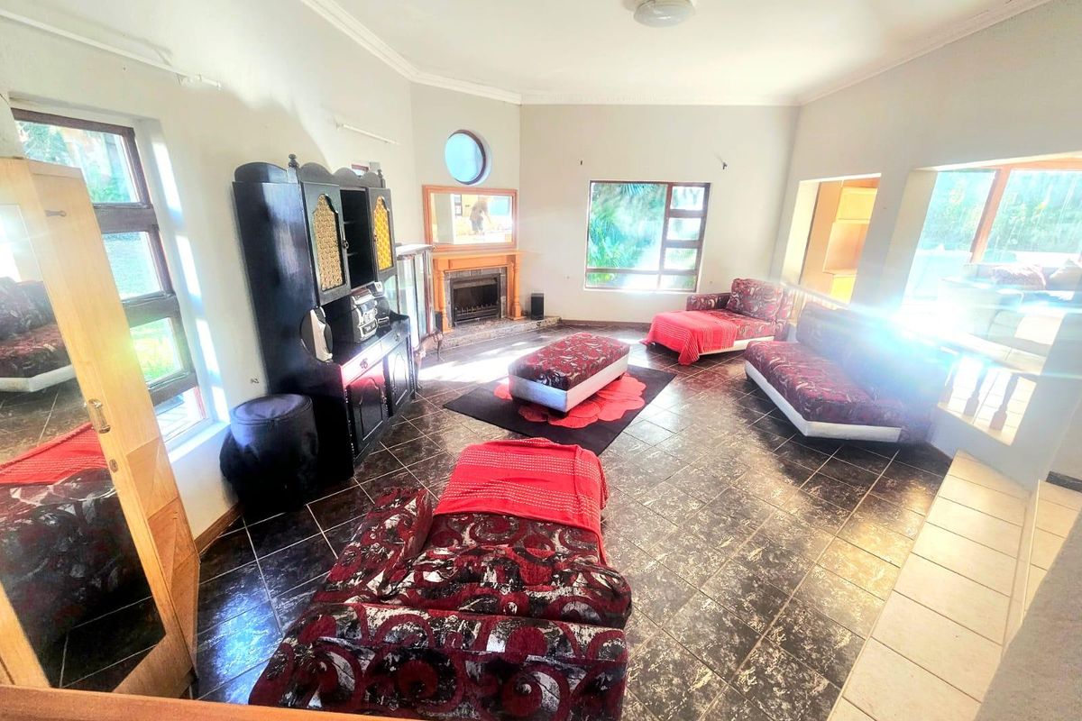 Spacious living room featuring tiled flooring, a built-in fireplace, and large windows that provide ample natural light.