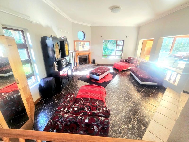 Spacious living room featuring tiled flooring, a built-in fireplace, and large windows that provide ample natural light.
