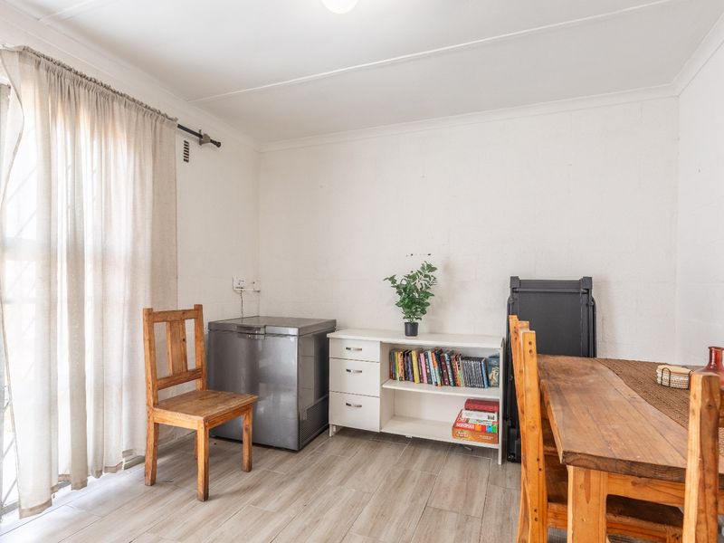 A functional dining area featuring tiled flooring and a sliding glass door providing access to the exterior.