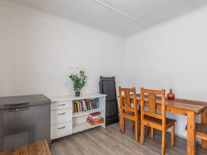 A functional dining area featuring tiled flooring and neutral walls, providing a versatile space for meals and daily activities.