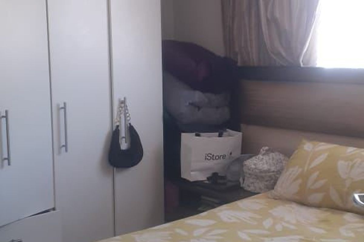 A compact bedroom featuring a built-in wardrobe and a headboard, providing functional storage and sleeping space.
