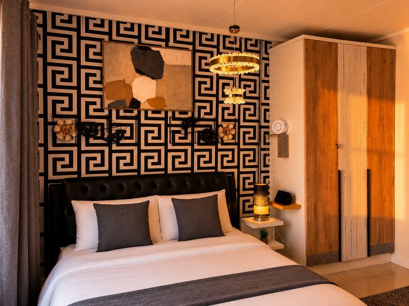 A well-appointed bedroom featuring a built-in wardrobe with wood-grain finish and a decorative geometric accent wall.