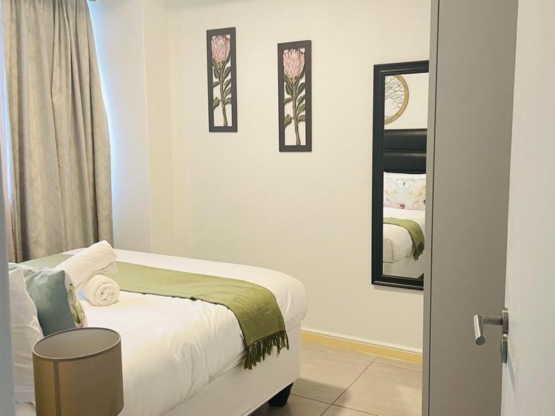 A well-maintained bedroom featuring neutral tiled flooring and clean wall finishes, providing a comfortable and functional living space.