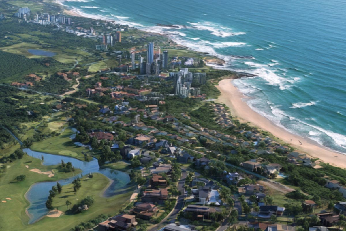 An aerial view of a coastal residential estate featuring a golf course, lush greenery, and proximity to the ocean.