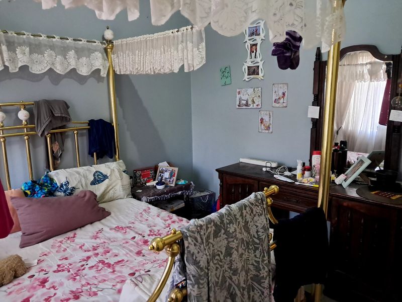 A bedroom featuring a four-poster bed frame and a built-in vanity area.