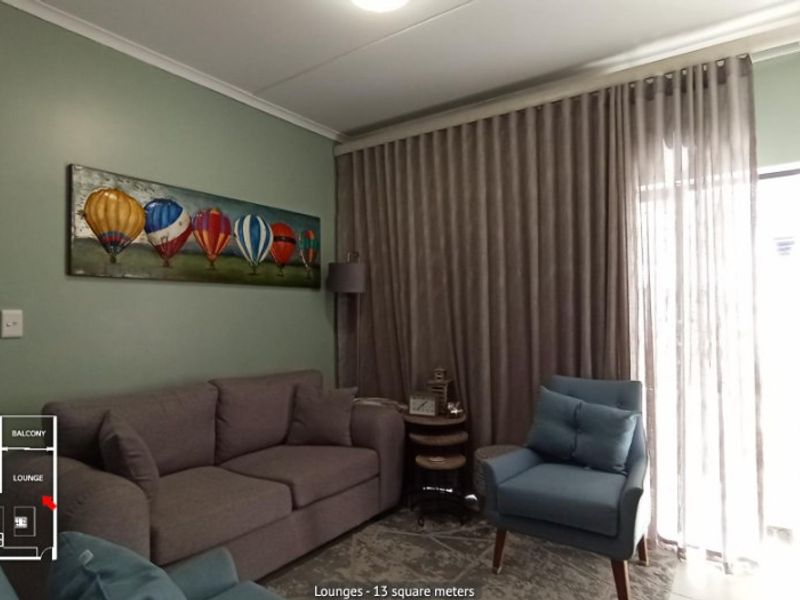 A comfortable living room featuring a sliding glass door with floor-to-ceiling curtains, providing access to the balcony area.