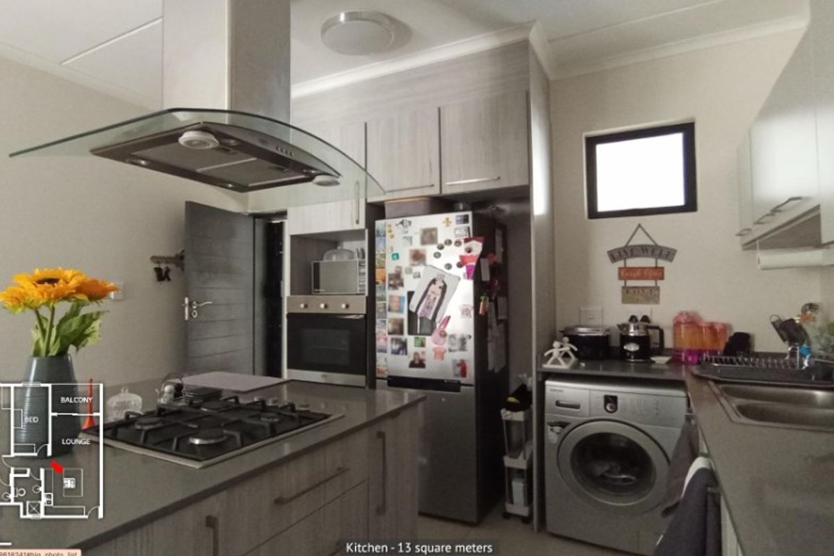 Modern kitchen featuring stone countertops, gas hob, extractor fan, built-in oven, and ample cabinetry with an integrated laundry area.