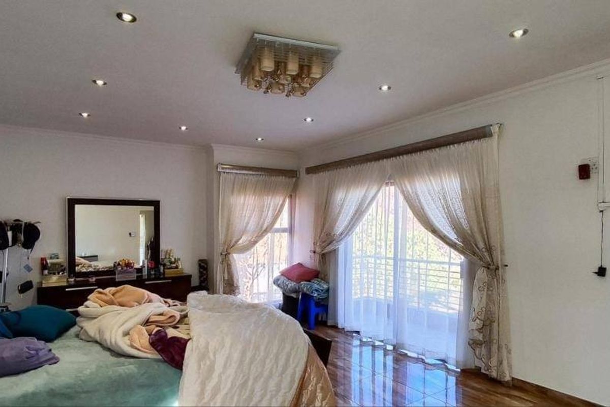 Spacious bedroom featuring tiled flooring, recessed downlighting, and a sliding glass door providing access to an outdoor area.