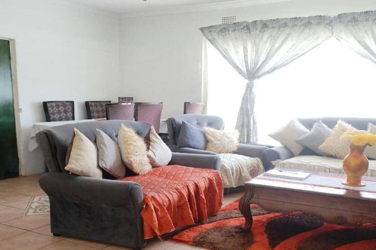 A spacious living area featuring tiled flooring and neutral wall finishes, providing a comfortable and functional space for relaxation.