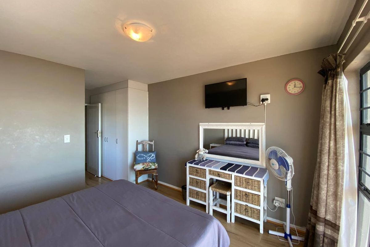 A bedroom featuring laminate flooring and built-in cupboards, providing functional storage space within the apartment.