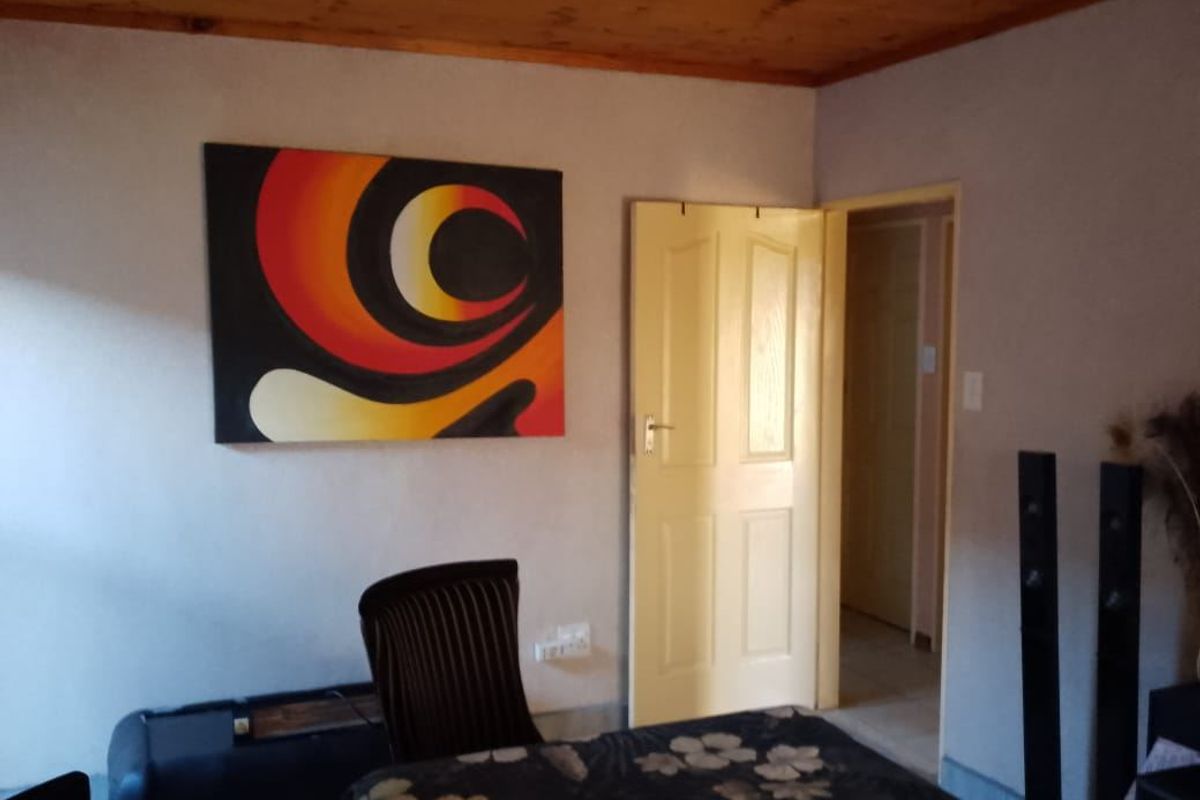 A living room area featuring a timber ceiling and an internal door leading to an adjacent space.