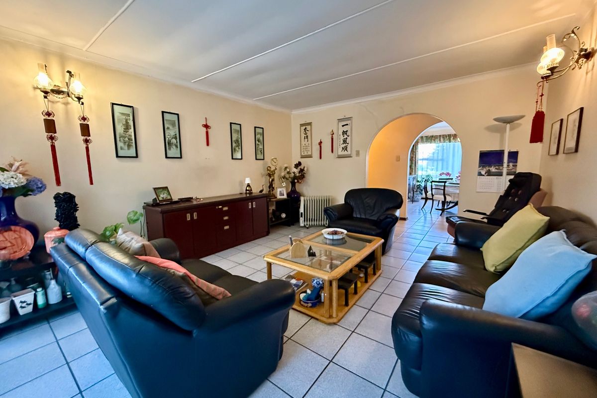 Spacious living room featuring tiled flooring and an arched entryway leading to an adjacent dining area.
