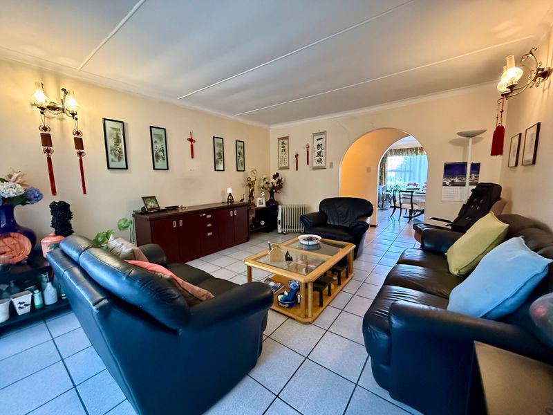 Spacious living room featuring tiled flooring and an arched entryway leading to an adjacent dining area.