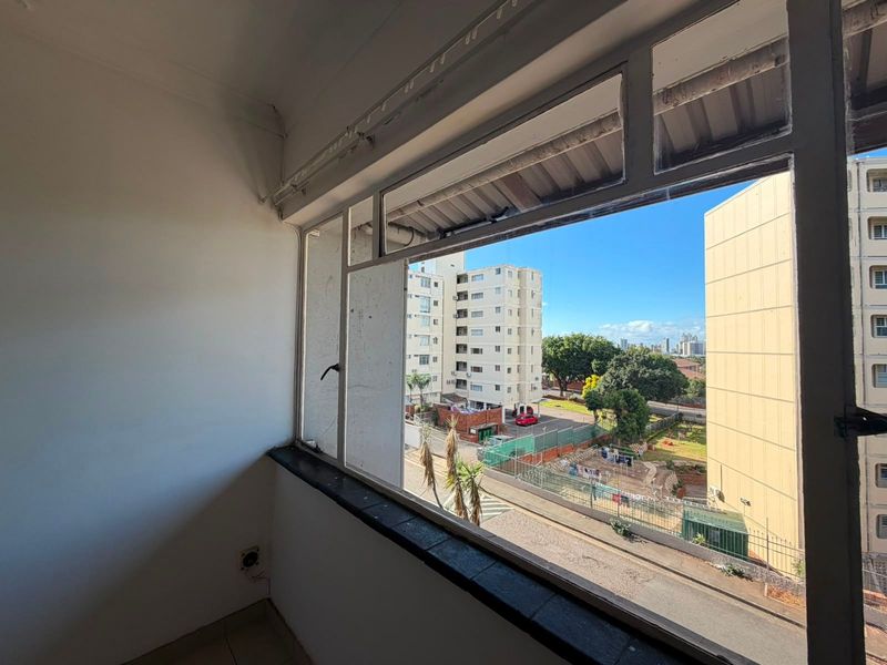 A view from an apartment window overlooking surrounding residential buildings and urban landscape.