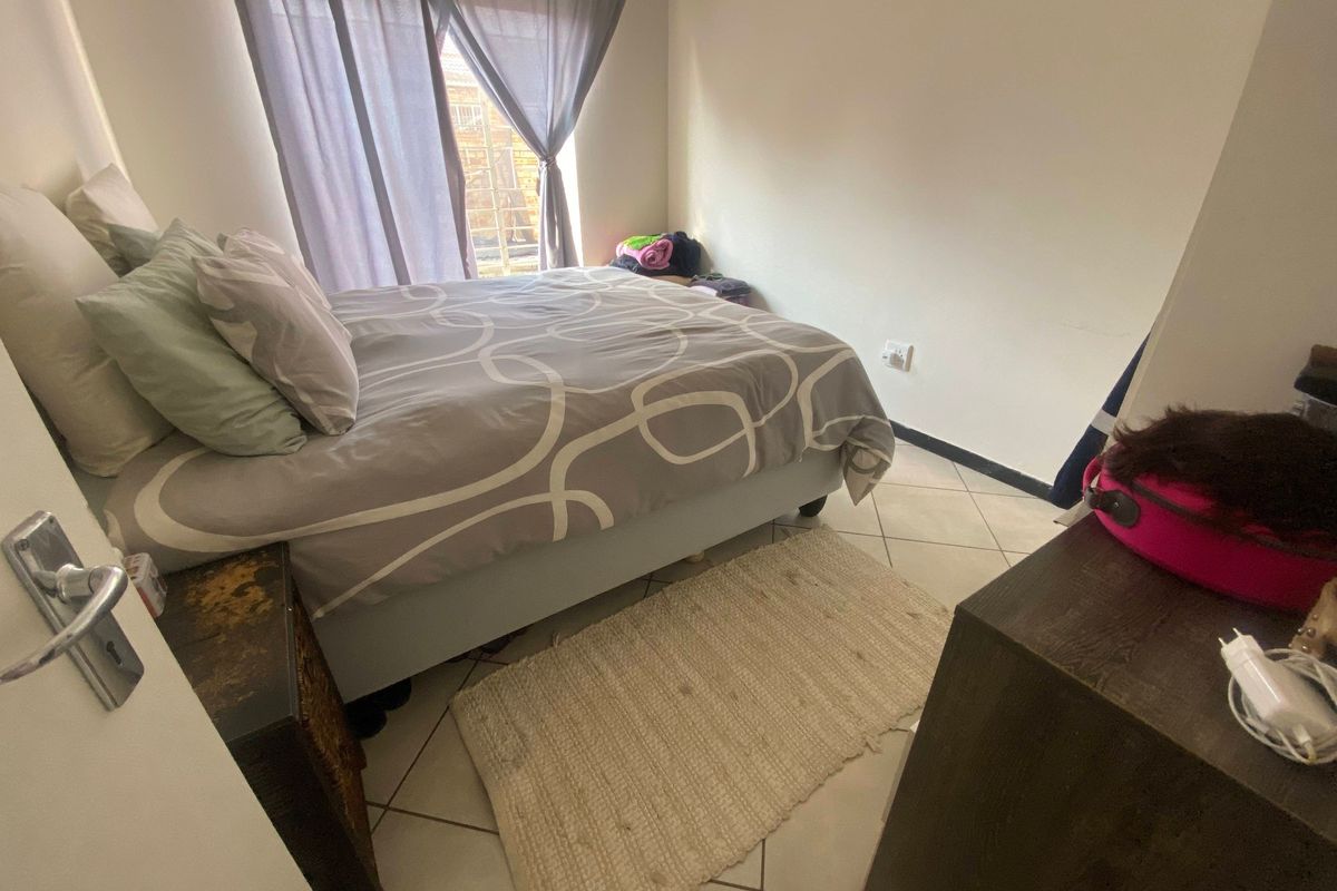 A standard bedroom featuring tiled flooring and natural light from the window.