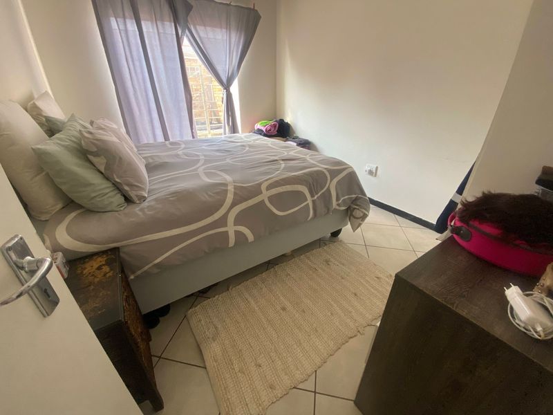 A standard bedroom featuring tiled flooring and natural light from the window.