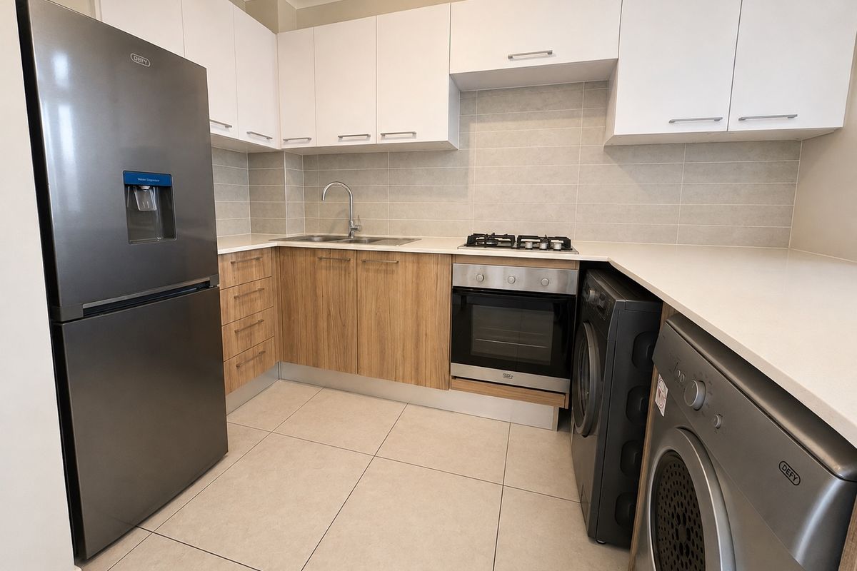 Modern kitchen featuring sleek white and wood-grain cabinetry, stone countertops, integrated gas hob, built-in oven, and neutral tiled flooring.