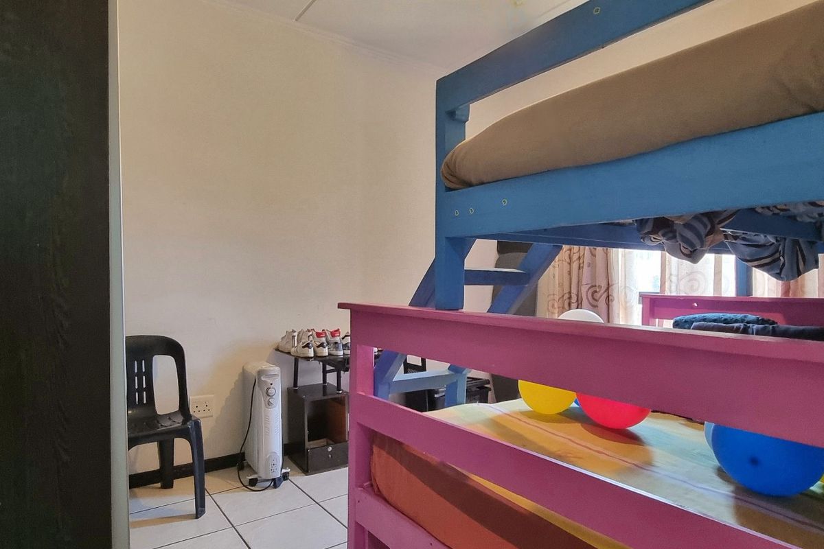 A bedroom featuring tiled flooring and a built-in cupboard, currently utilized as a children's room.