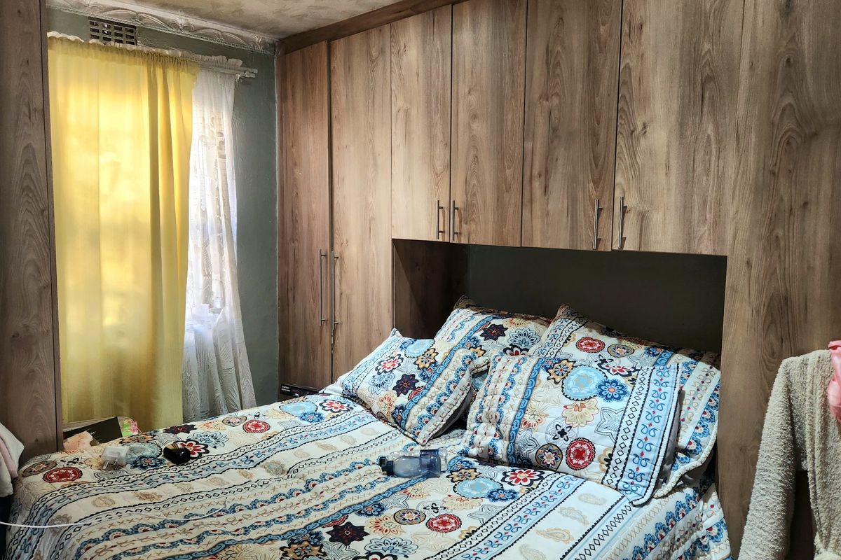 Bedroom featuring extensive floor-to-ceiling built-in wooden cupboards and recessed lighting, providing ample storage space.