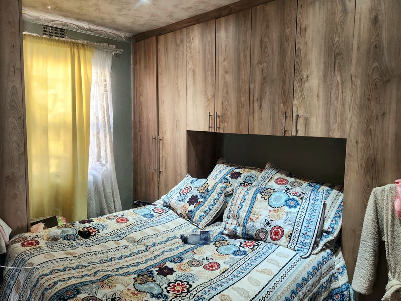 Bedroom featuring extensive floor-to-ceiling built-in wooden cupboards and recessed lighting, providing ample storage space.