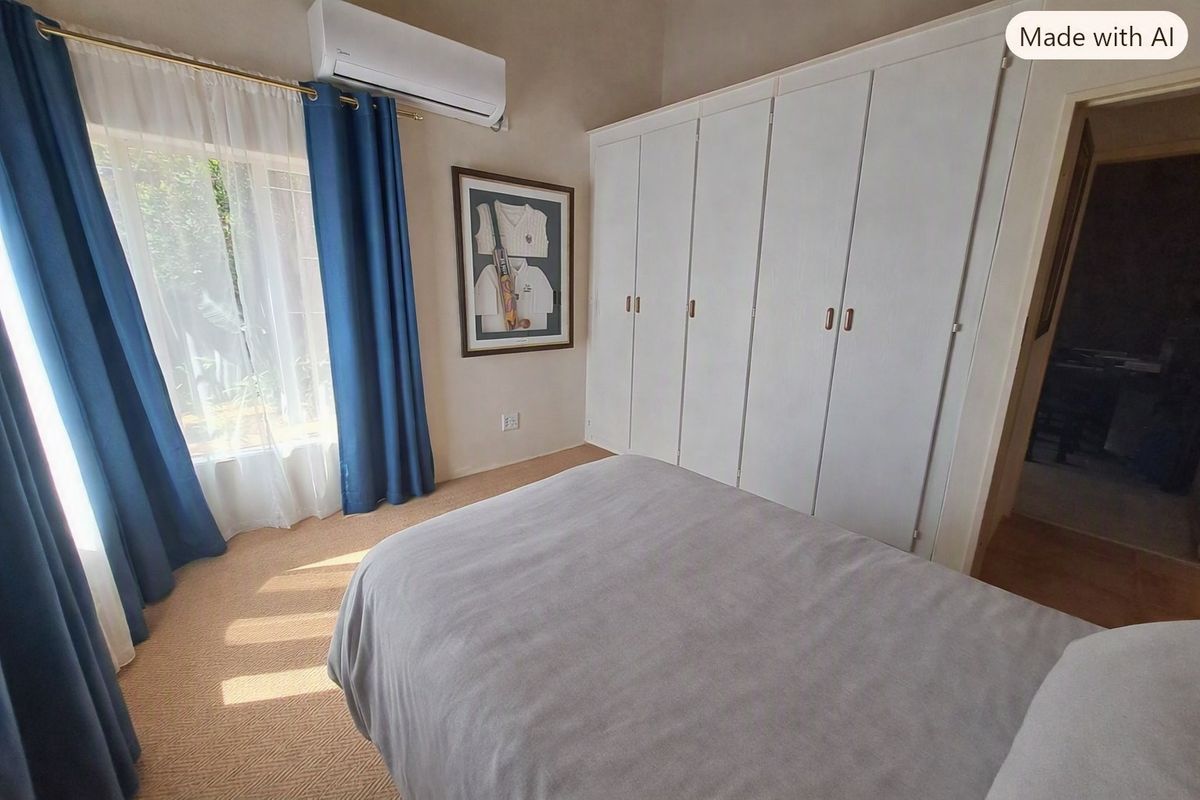 A well-maintained bedroom featuring built-in cupboards, carpeted flooring, and a wall-mounted split-system air conditioning unit.