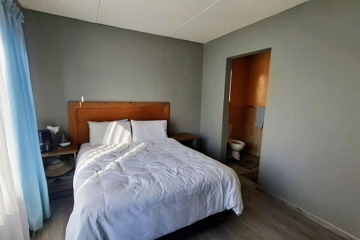 A bedroom featuring laminate flooring and direct access to an en-suite bathroom.