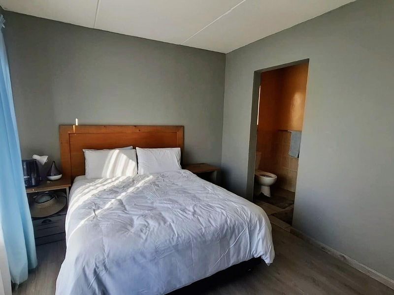 A bedroom featuring laminate flooring and direct access to an en-suite bathroom.