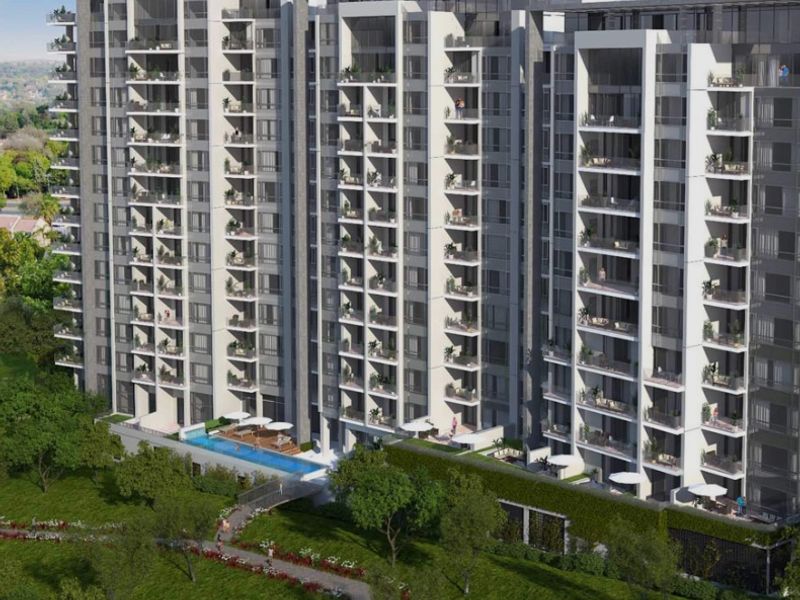 Aerial view of a modern high-rise apartment complex featuring extensive balconies, a swimming pool, and landscaped grounds.