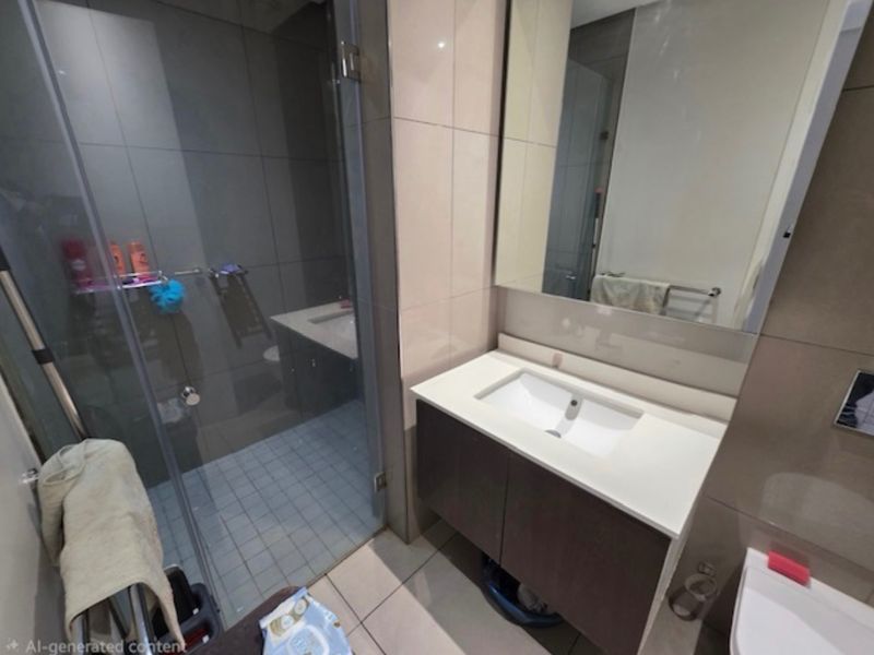 Modern bathroom featuring a glass-enclosed shower, wall-mounted vanity with integrated basin, and large wall mirror with neutral tiling throughout.