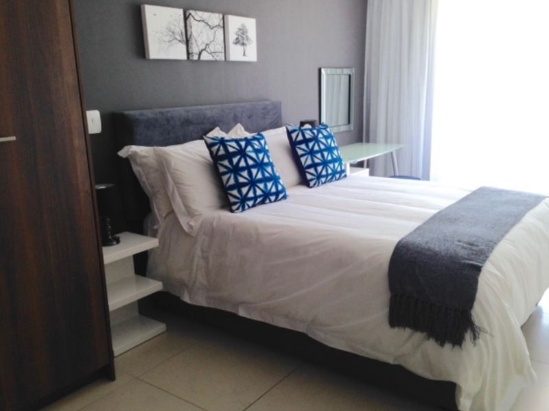A well-maintained bedroom featuring tiled flooring and a built-in wardrobe, offering a clean and functional living space.
