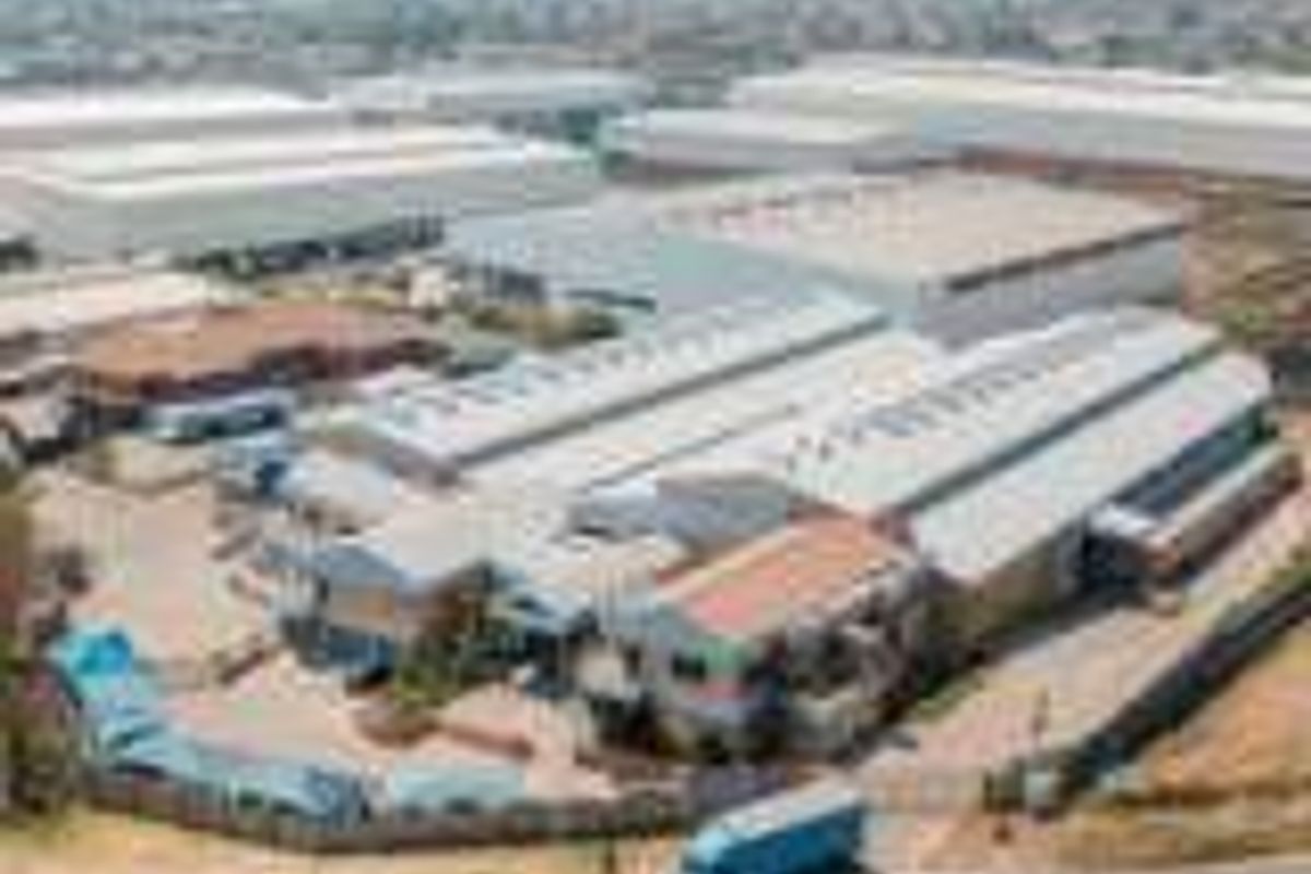 Aerial view of an industrial warehouse complex featuring multiple large-scale buildings, paved yard space, and secure perimeter fencing.
