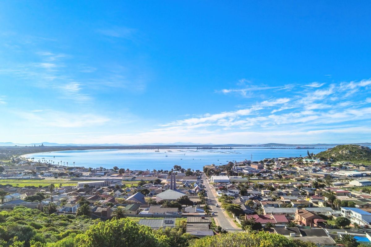 A panoramic aerial view overlooking the coastal town and bay, showcasing the surrounding landscape and residential area.