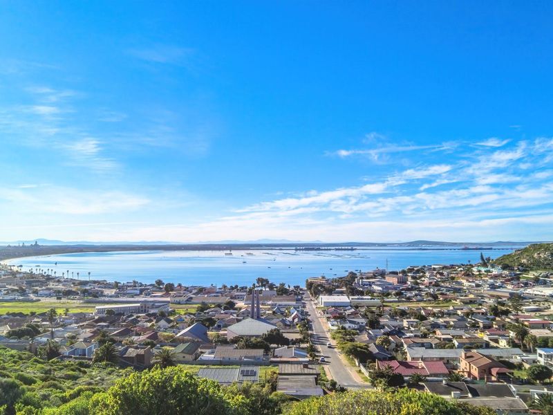 A panoramic aerial view overlooking the coastal town and bay, showcasing the surrounding landscape and residential area.