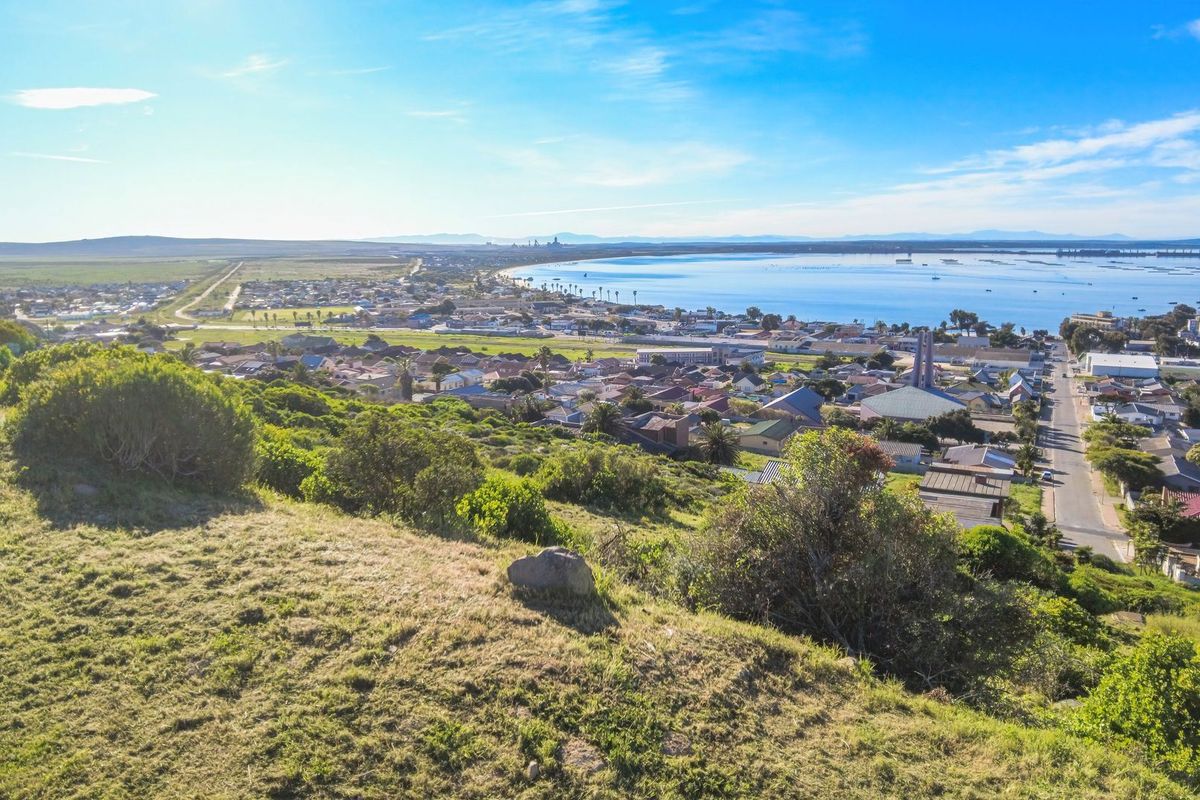 An elevated aerial view overlooking a coastal town, residential area, and the surrounding landscape.